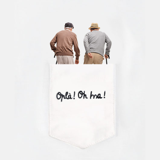 Dettaglio della maglietta con due nonni di spalle a passeggio nel taschino della T-Shura "Oplà Oh Issa"" le magliette dei nonni, la frase dei nonni e degli umarell è ricamata in nero t-sciura